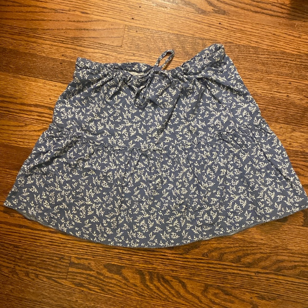 Blue Brandy Melville skirt with white flower design.